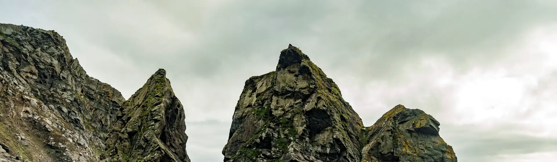 Panoramic view of a rugged mountain range with three prominent rocky peaks