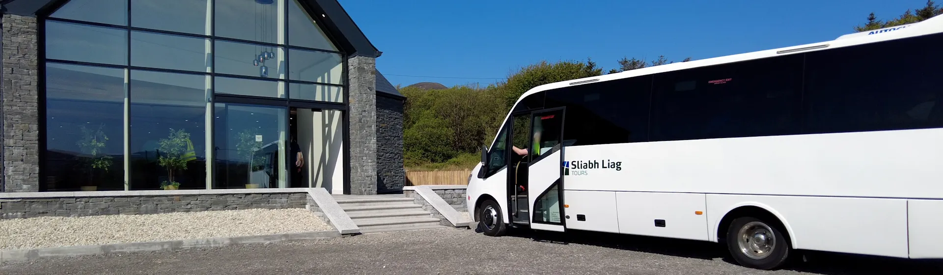 Sliabh Liag Shuttle Bus is parked in front of a building