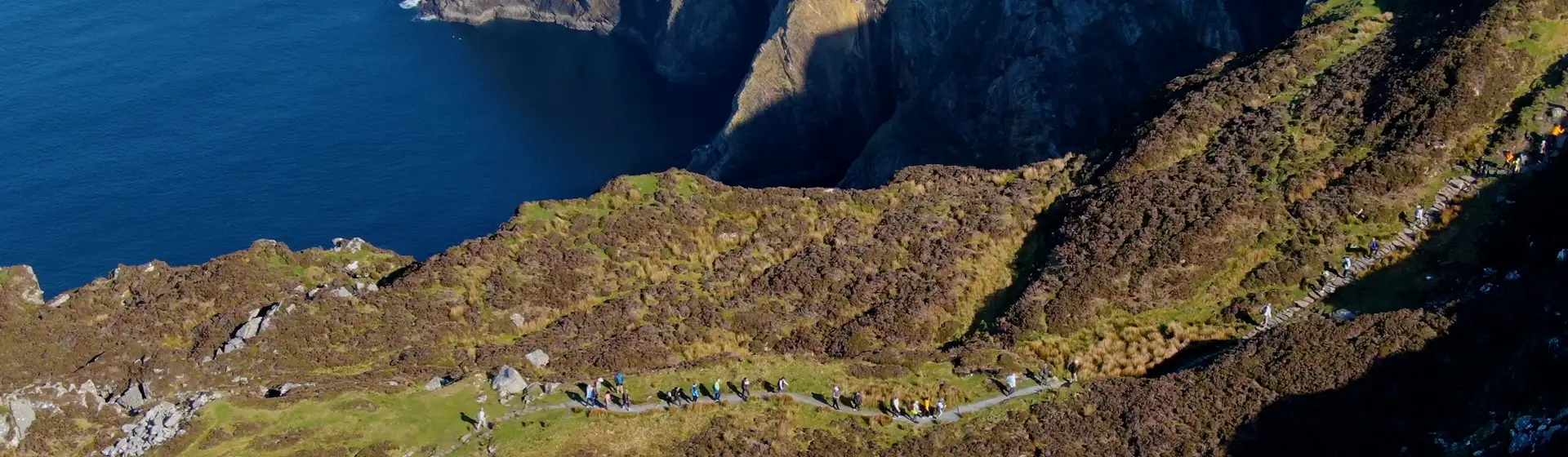 Scenic aerial view of a group on the rocky coastline of Sliabh Liag Cliff